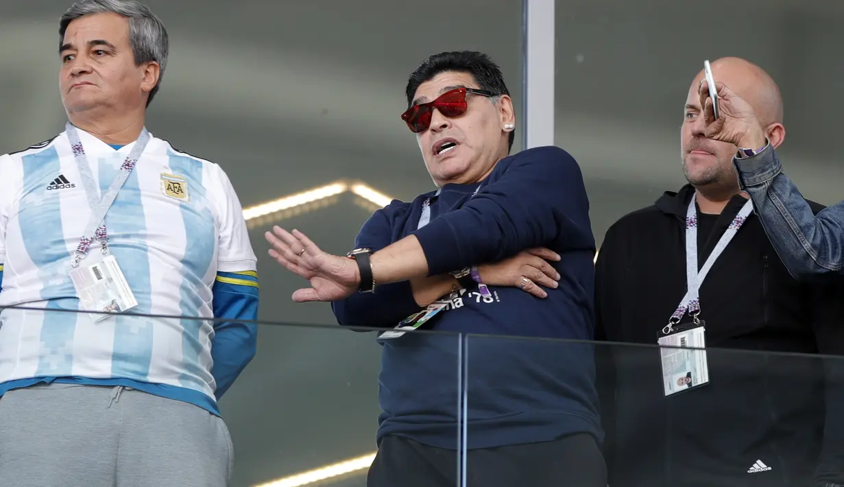 Diego Maradona (tengah) menyapa penggemar saat menyaksikan laga Argentina melawan Islandia pada grup D Piala Dunia 2018 di Spartak Stadium, Moskow (16/6/2018). Argentina hanya bermain imbang 1-1. (AP/Ricardo Mazalan)
