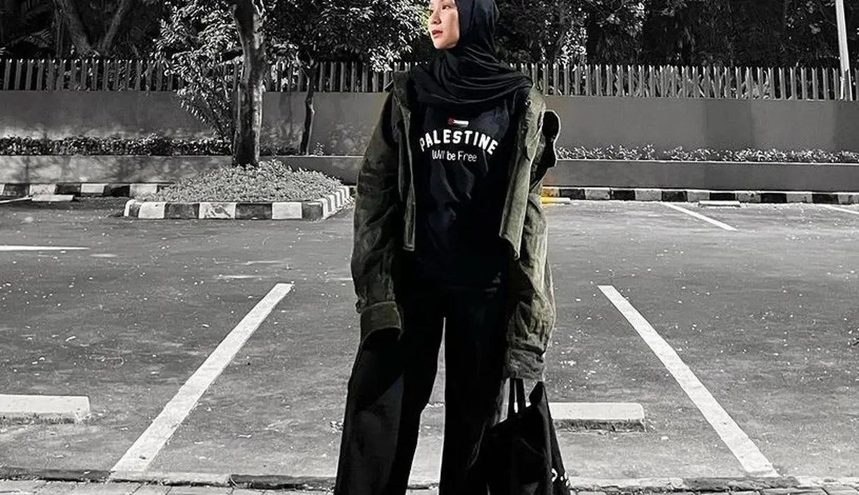 Zaskia juga mengenakan kaos hitam bertuliskan Palestine Will be Free yang dipadukan kerudung dan celana hitam serasi dengan totebagnya. Ia juga mengenakan outer kemeja hijau army.  [@zaskiadyamecca]