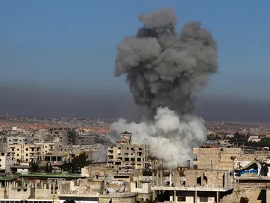 Asap mengepul setelah serangan udara pemerintah Suriah di Distrik Maaret al-Numan, Provinsi Idlib, Rabu (18/12/2019). Serangan udara dan penembakan tersebut telah menewaskan 23 warga sipil, termasuk anak-anak. (Abdulaziz KETAZ/AFP)