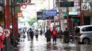 Warga melintas di kawasan pertokoan Pasar Baru, Jakarta, Kamis (2/1/2020). Pasca banjir yang melanda sejumlah titik di Jakarta pada Rabu (1/1), aktivitas perniagaan di kawasan Pasar Baru masih terlihat sepi dan sebagian toko masih tutup. (Liputan6.com/Helmi Fithriansyah)
