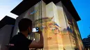 Seorang pria mengabadikan foto pertunjukan lampu sorot yang ditampilkan di Perpustakaan Sichuan, Chengdu, Provinsi Sichuan, China, 29 September 2020. Serangkaian pertunjukan cahaya dan lampu sorot digelar di Chengdu setiap malam dari 29 September hingga 10 Oktober mendatang. (Xinhua/Zhang Kefan)