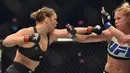 Ronda Rousey, berusaha memukul Holly Holm, pada pertarungan perebutan gelar juara kelas bantam UFC Women di Stadion Etihad, Melbourne, Minggu (15/11/2015). (AFP Photo/Paul Crock)