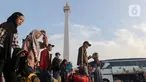 Calon pemudik saat tiba di kawasan Monumen Nasional, Jakarta, Kamis (4/4/2024). (Liputan6.com/Herman Zakharia)