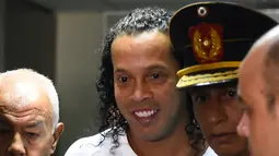 Mantan pemain timnas Brasil, Ronaldinho tiba memberikan keterangan di Asuncion's Justice Palace, ibu kota Paraguay, Jumat (6/3/2020). Ronaldinho bersama saudara laki-lakinya berurusan dengan pihak berwenang Paraguay karena menggunakan paspor palsu untuk memasuki negara itu. (Norberto DUARTE/AFP)