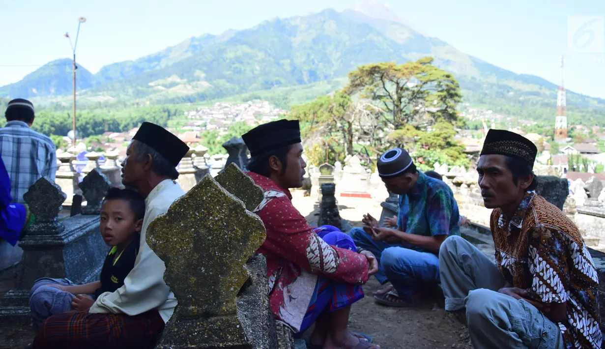 Warga berdoa di makam Desa Selo, Kabupaten Boyolali, Kamis (3/5). Tradisi ini Sebagai perayaan menyambut datangnya bulan ramadan, kemudian dilanjutkan makan bersama di pertigaan jalan desa. (Liputan6.com/Gholib)
