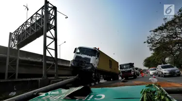 Kendaraan berat kontainer menabrak jalur pembatas pintu masuk tol akses Tanjung Priok di Jalan Raya Cilincing, Jakarta Utara, Sabtu (17/8/2019). Kejadian pada pukul 03.00 dini hari tadi terjadi akibat sopir mengantuk. Tidak ada korban jiwa dalam kejadian ini. (merdeka.com/Arie Basuki)