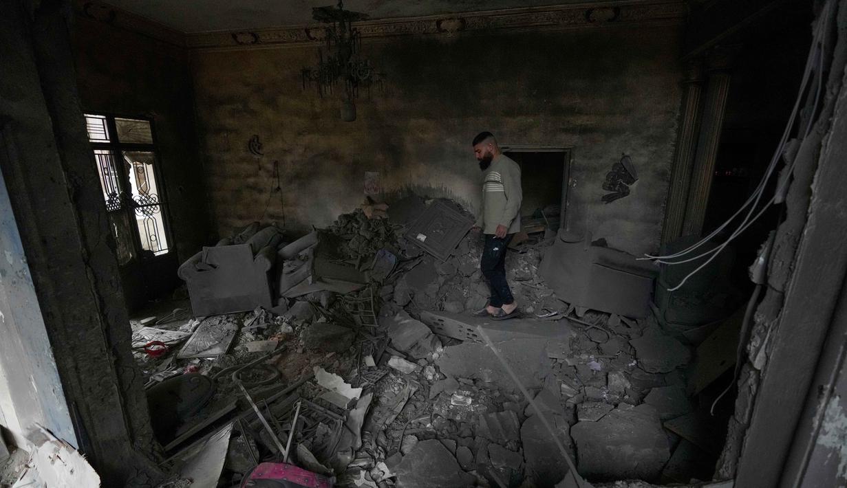 Sebelumnya, militer Israel telah mengumumkan akan memperluas serangan darat dan udara terhadap kelompok milisi Hizbullah di Lebanon. Tampak dalam foto, seorang pria memeriksa apartemennya di lokasi bangunan yang hancur akibat serangan udara Israel di kota pelabuhan Tyre, Lebanon selatan, Kamis, 26 Maret 2026. (AP Photo/Hussein Malla)