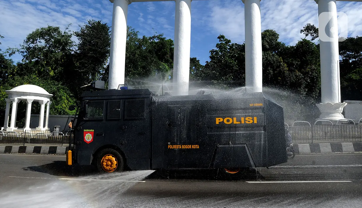 Petugas kepolisian Polresta Bogor menyemprotkan cairan disinfektan menggunakan mobil Water Cannon di kawasan Tugu Kujang, Bogor, Selasa (31/3/2020). Penyemprotan disinfektan secara menyeluruh di wilayah Kota Bogor itu guna mencegah memutus rantai penyebaran virus corona. (merdeka.com/Arie Basuki)