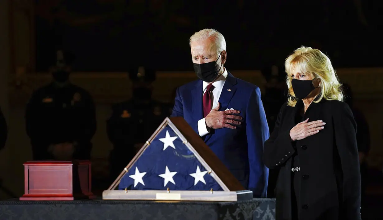 Presiden AS Joe Biden dan Ibu Negara Jill Biden memberi penghormatan kepada polisi yang tewas dalam kerusuhan Capitol Hill Brian Sicknick di tengah Capitol Rotunda, Washington, Selasa (2/2/2021). Abu jenazah Brian Sicknick dihadirkan dalam upacara ini. (Erin Schaff/The New York Times via AP, Pool)