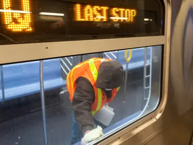 Pekerja otoritas transportasi kota New York membersihkan gerbong kereta bawah tanah di stasiun Coney Island di Brooklyn, Rabu (6/5/2020). Untuk pertama kalinya, sistem kereta bawah tanah New York dimatikan sementara agar dapat dibersihkan untuk menghentikan penyebaran virus corona (COREY SIPKIN/AFP)