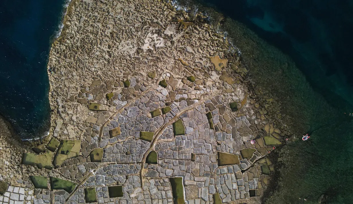 Foto dari udara pada 7 September 2020 ini menunjukkan dataran garam dengan pematang batu di sebuah desa di Gozo, Malta. Dikelilingi seluruhnya oleh laut, Malta merupakan salah satu produsen besar garam laut yang dihasilkan dari dataran garam berpematang batu. (Xinhua/Jonathan Borg)