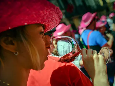 Seorang wanita mencicipi segelas anggur mawar Spanyol untuk mempromosikan minuman tersebut di Pamplona, Spanyol, Sabtu (19/5). Anggur mawar Spanyol merupakan minuman khas wilayah tersebut. (AP Photo/Alvaro Barrientos)