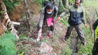 Beberapa saksi mata tengah menunjukan lokasi penemuan kasus pembuangan jasad bayi di Kampug Ciarileu, Kecamatan Cikajang, Garut, Jawa Barat yang ditemukan sudah tidak utuh tanpa tangan dan kepala. (Liputan6.com/Jayadi Supriadin)