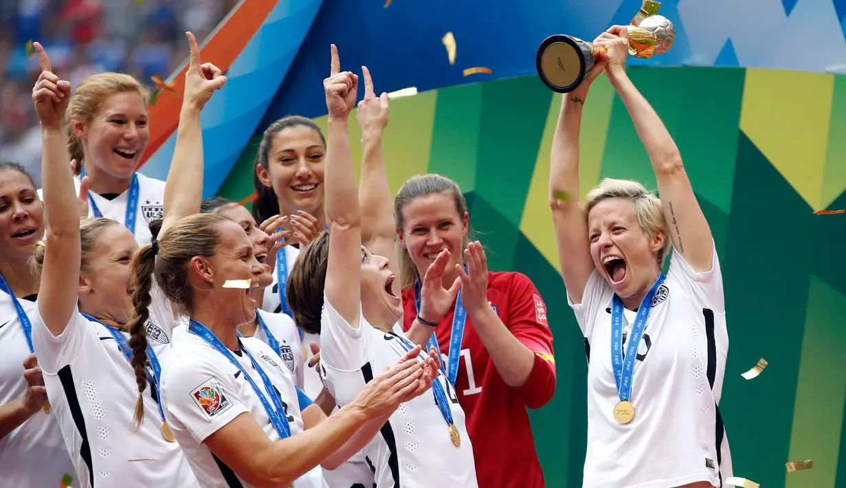 Gelandang AS, Megan Rapinoe (kanan) mengangkat trofi merayakan dengan pemain lainya usai memenangkan gelar juara Piala Dunia wanita 2015 di BC Place, Kanada, Senin (6/7/2015). Amerika berhasil mengalahkan Jepang dengan skor 5-2.  (Reuters/Michael Chow)
