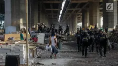 Petugas Satpol PP dengan pakaian anti huru hara lengkap mengamankan kegiatan penertiban bedeng liar di bawah kolong Tol Teluk Intan, Jakarta, Rabu (14/6). (Liputan6.com/Faizal Fanani)