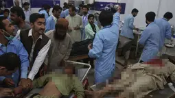 Petugas medis mengevakuasi sejumlah korban ledakan bom bunuh diri di Quetta, Pakistan, (13/7). ISIS telah menyatakan bertanggung jawab atas aksi serangan bom bunuh diri tersebut. (AP Photo/Arshad Butt)