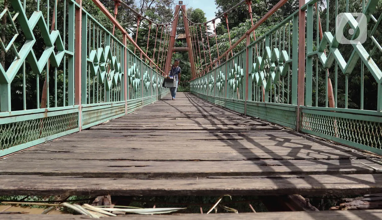 Kondisi jembatan yang berlubang di Jembatan Wiratman, Srengseng Sawah, Jakarta, Sabtu (12/3/2022). Jembatan tersebut mengalami kerusakan pada papan pijak yang mulai berlubang serta besi yang berkarat dan dapat membahayakan warga yang melintas. (Liputan6.com/Herman Zakharia)