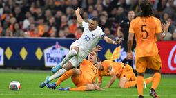 Pemain Prancis, Kylian Mbappe, terjatuh saat berusaha melewati pemain Belanda, Joey Veerman, pada Kualifikasi EURO 2024 Grup B di Stadion Johan Cruijff Arena, Sabtu (14/10/2023). Barisan pertahanan samapi harus melakukan pelanggaran untuk menghentikan Mbappe. (AFP/John Thys)