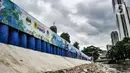 Seniman saat menyelesaikan pembuatan mural di turap Kanal Banjir Barat, Jakarta, Rabu (13/1/2021). Pembuatan mural bertemakan "Kehidupan Sungai" yang dikerjakan oleh seniman dari Komunitas Mural Depok tersebut bertujuan mempercantik lingkungan di sekitar Kali Ciliwung. (merdeka.com/Iqbal S. Nugroho)