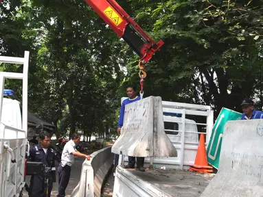 Petugas Dishub membongkar beton pembatas Jalan M. Yamin di depan bekas gedung Kedubes Inggris, Jakarta, Kamis (17/9/2015). Pembongkaran dilakukan karena beton tersebut akan dipergunakan di tempat lain. (Liputan6.com/Angga Yuniar)