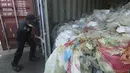 Petugas membuka peti kemas berisi sampah plastik yang mengandung limbah berbahaya dan beracun (B3) untuk di re-ekspor di Batam, Senin (29/7/2019). Indonesia mengirim kembali (re-ekspor) tujuh peti kemas berisi limbah plastik impor ke negara asalnya, Prancis dan Hongkong. (SEI RATIFA/AFP)