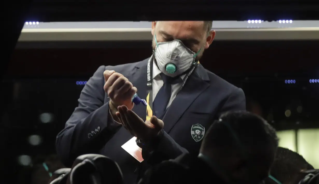 Seorang staf Ludogorets mengenakan masker sebelum turun dari bus menuju stadion San Siro, Milan, Italia (27/2/2020). Penggunaan masker dilakukan untuk mencegah Virus Korona yang telah menyebabkan 11 orang meninggal dunia di Italia. (Ludogorets FC via AP)