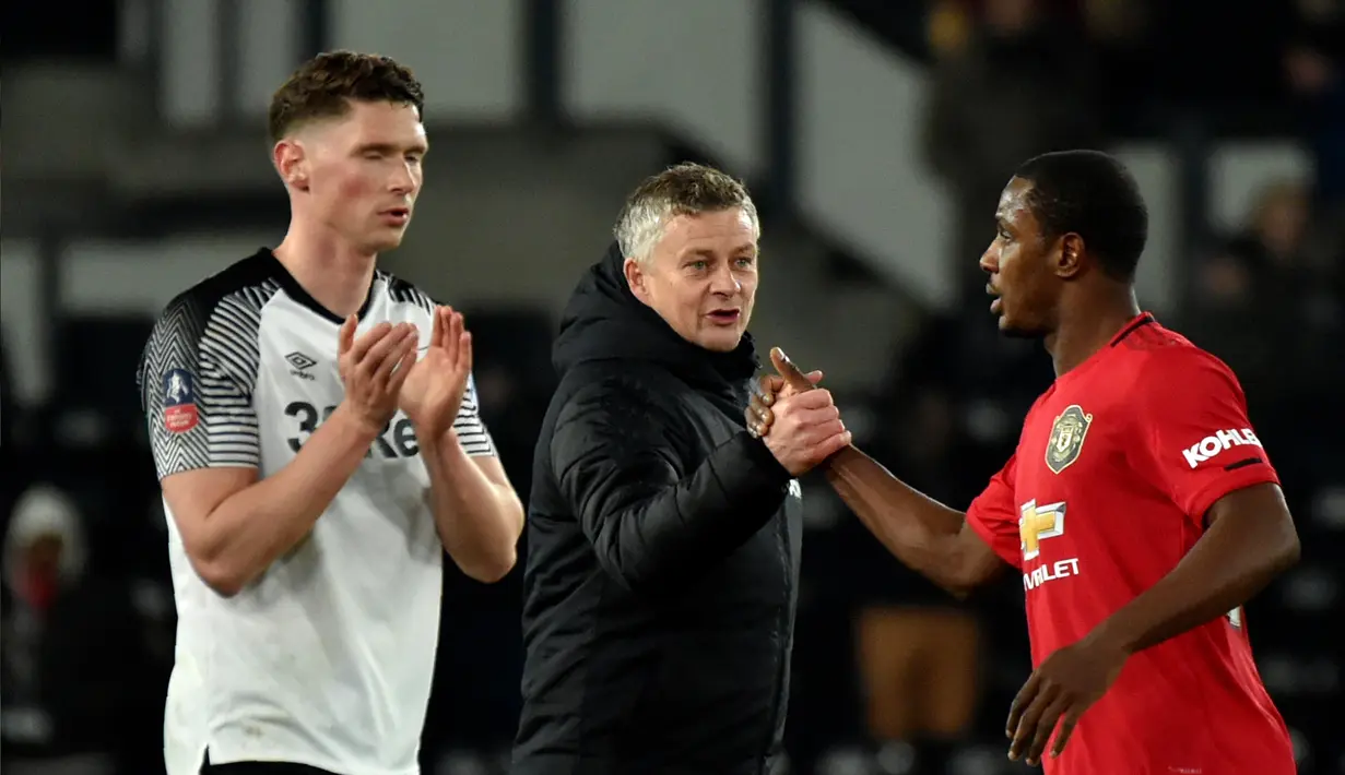 Manajer Manchester United Ole Gunnar Solskjaer (tengah) berjabat tangan dengan pemain Manchester United Odion Ighalo (kanan) pada akhir pertandingan putaran kelima Piala FA menghadapi Derby County di Pride Park, Derby, Inggris, Kamis (5/3/2020). Manchester United menang 3-0. (AP Photo/Rui Vieira)