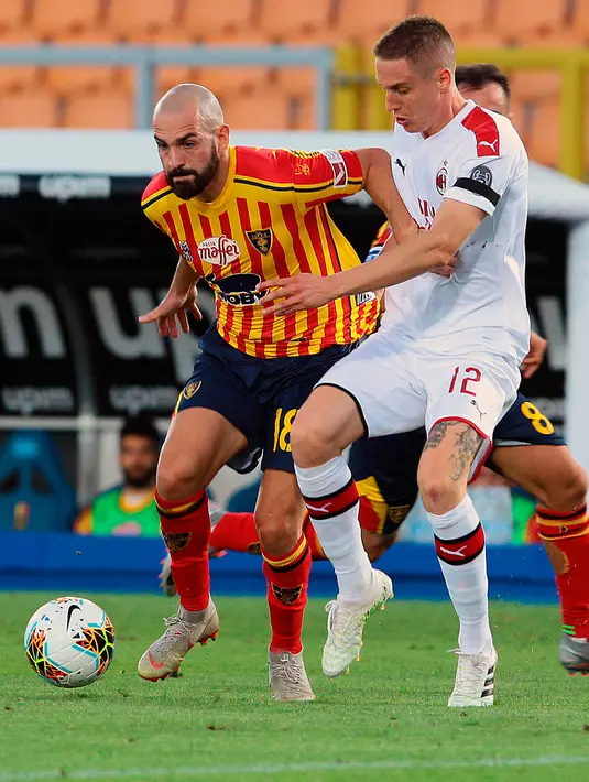 Bek AC Milan, Andrea Conti berusaha merebut bola yang dibawa pemain Lecce, Riccardo sayonara  pada pertandingan lanjutan liga Serie A Italia di stadion Via del Mare di Lecce, Italia (22/6/2020). AC Milan menang telak atas Lecce 4-1. (Donato Fasano / LaPresse via AP )