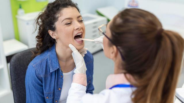 Seorang Dokter sedang Memeriksa Kondisi Lidah Pasien