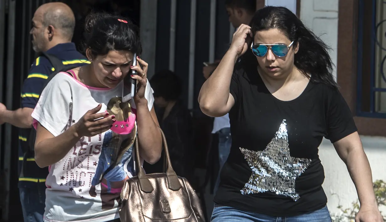 Kerabat penumpang pesawat EgyptAir berjalan meninggalkan ruang layanan informasi di Bandara Kairo, Kamis (19/5). Pesawat EgyptAir yang lepas landas dari Paris hilang kontak ketika baru memasuki wilayah udara Mesir sejauh 16 kilometer. (KHALED DESOUKI/AFP)