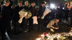 Grup band U2 Bono, Adam Clayton , Larry Mullen Jr  dan The Edge meletakkan karangan bunga di trotoar di depan gedung pertunjukan Bataclan Theatre, salah satu tempat serangan teroris di Paris, Perancis, Sabtu (14/11). (AFP PHOTO / FRANCK FIFE)