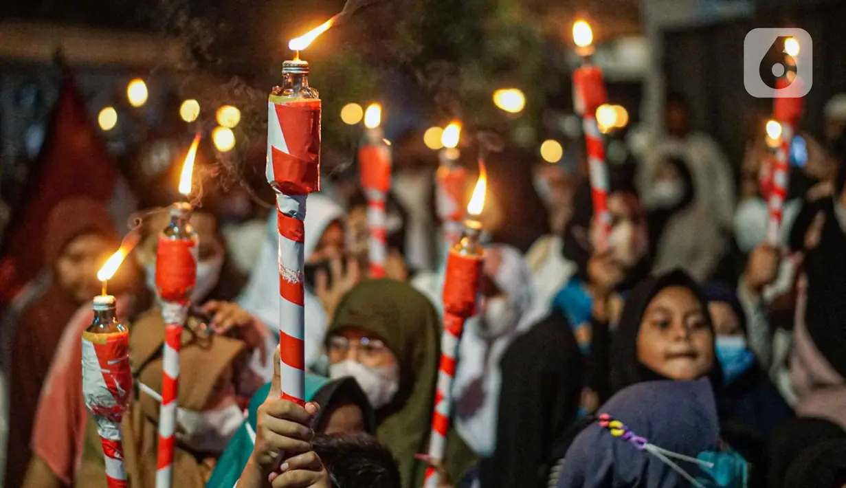 Warga mengikuti pawai obor menyambut Ramadan di kawasan Matraman Dalam, Jakarta, Minggu (27/3/2022). Pawai obor tersebut juga digelar untuk meningkatkan silaturahmi dan ukhuwah sesama umat Muslim serta menyemarakkan syiar Islam di Ibu Kota. (Liputan6.com/Faizal Fanani)