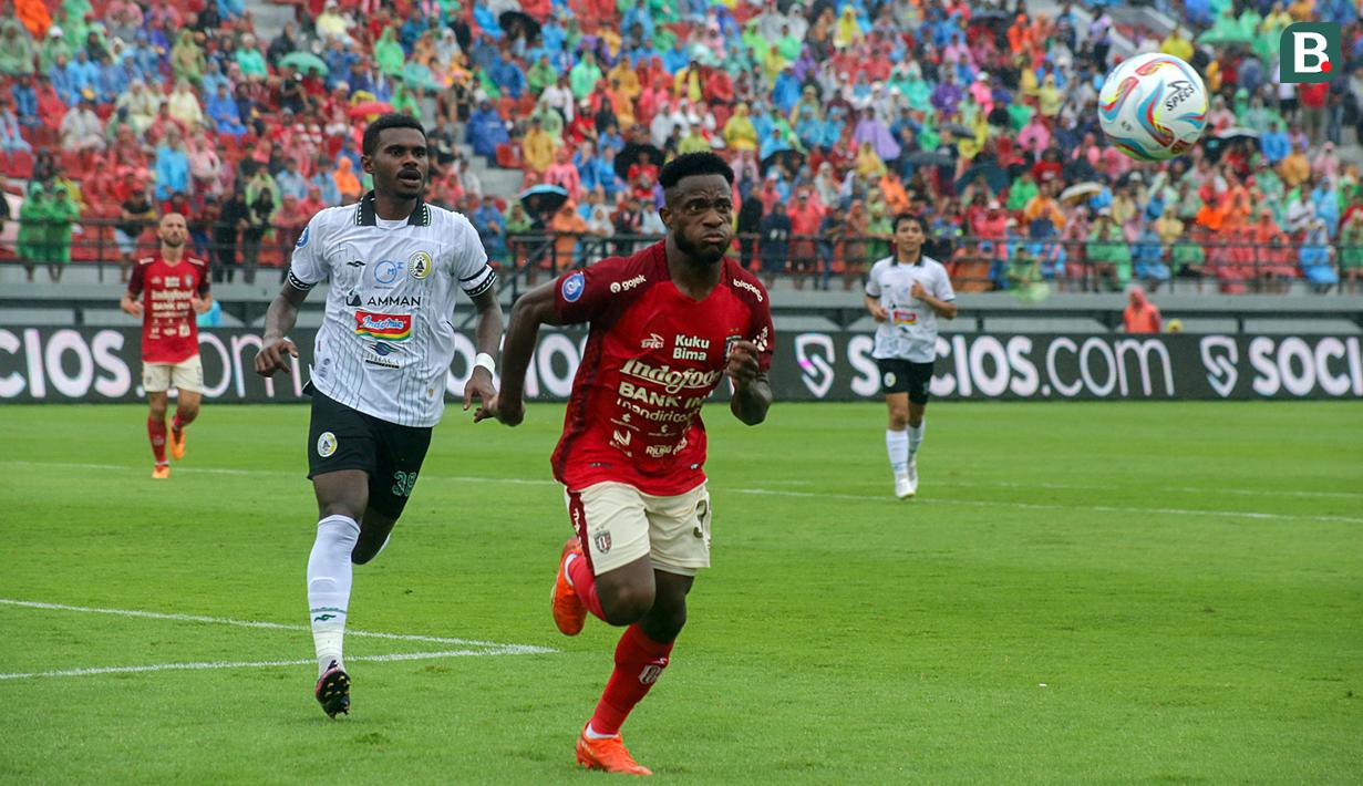 Pemain Bali United, Privat Mbarga (kanan), berusaha mengejar bola dibayangi pemain PSS Sleman, I Nyoman Nikson Ansanay, saat laga perdana BRI Liga 1 2023/2024 yang berlangsung di Stadion Kapten I Wayan Dipta, Gianyar, Sabtu (1/7/2023) sore WIB. (Bola.com/Alit Binawan)
