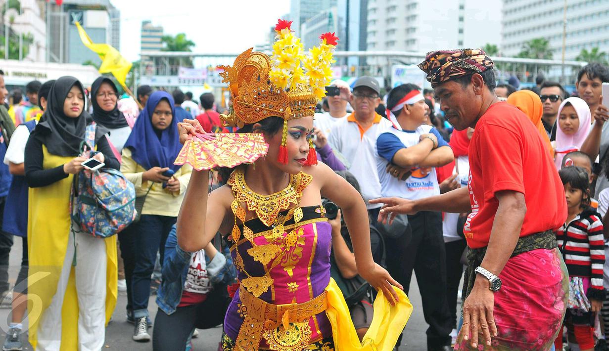 Seorang peserta ikut menari Tari Pendet khas Bali dalam parade kebudayaan bertajuk 'Kita Indonesia' di kawasan Bundaran HI, Jakarta, Minggu (4/12). Para peserta Parade Kebudayaan tampak antusias menyaksikan tarian itu. (Liputan6.com/Angga Yuniar)