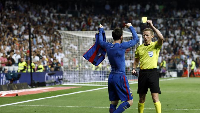 Lionel Messi mendapatkan kartu kuning usai berselebrasi dengan melepas jerseynya kala mencetak gol penentu kemenangan 3-2 Barcelona atas Real Madrid. (OSCAR DEL POZO / AFP)