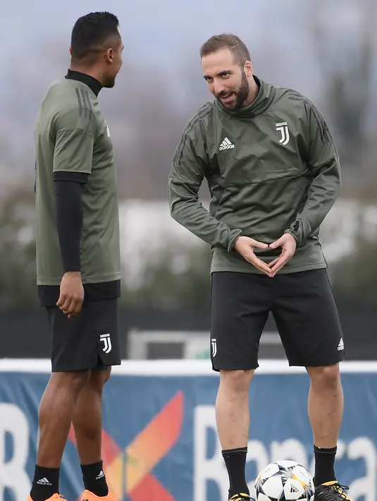 Penyerang Juventus, Gonzalo Higuain (kanan) berbincang dengan rekannya saat sesi latihan di pusat pelatihan Juventus di Vinovo (2/4). Juventus akan bertanding melawan Real Madrid. (AFP Photo/Marco Bertorello)