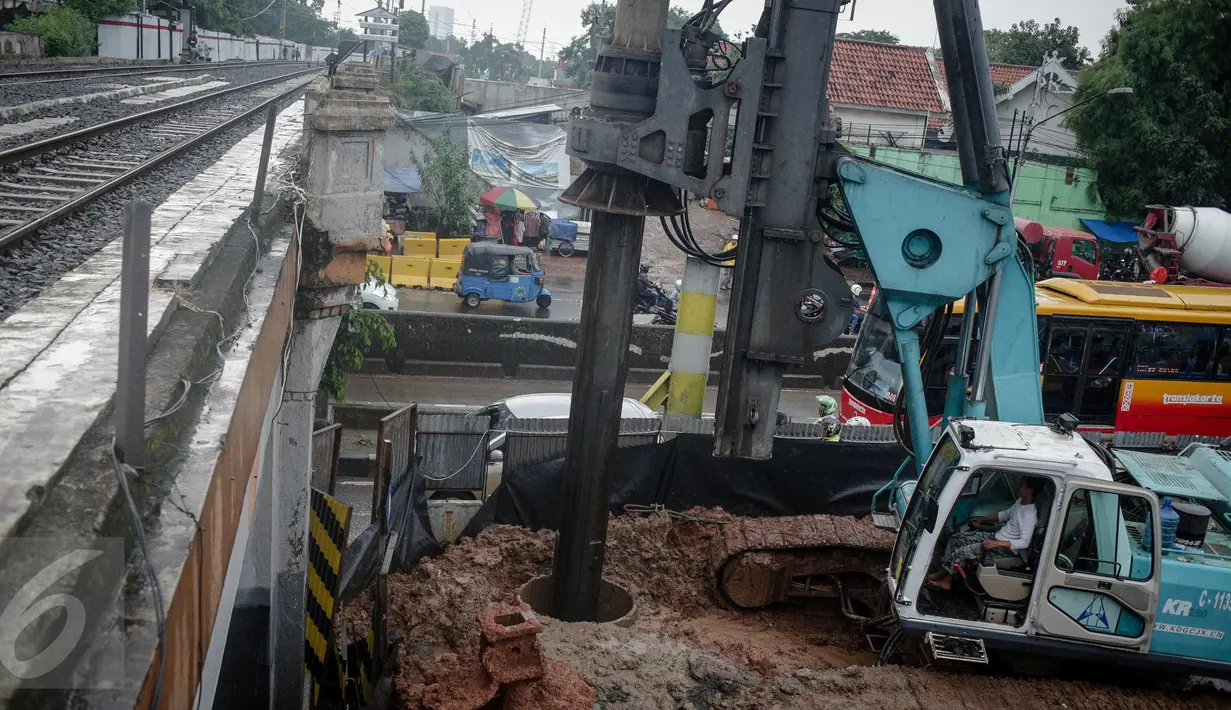 Pekerja menggunakan alat berat untuk membuat lubang yang akan pasang tiang pancang proyek double-double track (DDT) Paket A Manggarai-Jatinegara, Jakarta, Minggu (26/3). (Liputan6.com/Faizal Fanani)