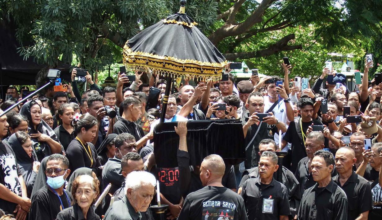 Prosesi ini diikuti oleh ribuan peziarah yang menggunakan ratusan kapal motor, sampan kecil, dan perahu nelayan yang memenuhi selat Larantuka. Tampak dalam foto, umat Katolik mengangkut peti mati berisi patung Yesus selama prosesi laut Jumat Agung dari Kapel Tuan Menino, sebuah ritual yang diwarisi dari pengaruh Portugis selama lebih dari lima abad, di Larantuka, Nusa Tenggara Timur, pada Jumat 3 April 2026. (ARNOLD WELIANTO/AFP)