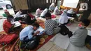 Murid kelas IV SD Muhammadiyah 37 belajar di teras rumah seorang guru di kawasan Pondok Cabe Udik, Tangerang Selatan, Banten, Senin (10/8/2020). Kegiatan belajar mengajar (KBM) tatap muka ini dilakukan karena murid kesulitan menguasai materi pelajaran saat belajar online. (merdeka.com/Arie Basuki)