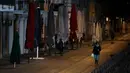 Beberapa orang berjalan di Kanal Naviglio Grande, Milan, Italia, Selasa (10/3/2020). Bar-bar yang biasa berjajar di sepanjang Kanal Naviglio Grande terlihat tutup menyusul dektrit lockdown yang berlaku di Italia demi mencegah penyebaran virus corona (COVID-19). (AP Photo/Antonio Calanni)