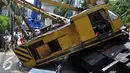 Sebuah crane jatuh di Jalan Kyai Maja, Kebayoran Baru, Jakarta Selatan, Kamis (15/10/2015). Alat besar yang tengah melakukan proyek ‎jalan layang ini menimpa salah satu rumah warga yang berada di sisi kanan jalan. (Liputan6.com/Helmi Afandi)