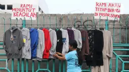 Pedagang sedang merapikan pakaian di kawasan luar pasar senen, Jakarta, Minggu (1/12/2019). Pedagang kaki lima di luar kawasan pasar senen menolak relokasi di pasar kenari, rencananya akan dipindahkan pada 1 Desember 2019 ini. . (Liputan6.com/Herman Zakharia)