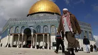 Seorang pria Palestina berjalan melewati Dome of Rock di kompleks Masjid Al-Aqsa sebelum sholat Jumat di Kota Tua Yerusalem pada tanggal 13 Januari 2017. (AFP/Ahmad Gharabli)