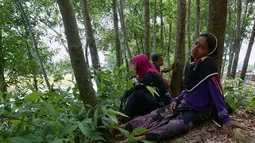 Wanita Rohingya bersama anak-anak berlindung di sebuah hutan sebelum pindah ke sebuah tempat peralihan di perbatasan Bangladesh di perbatasan, Ghumdhum, Bangladesh, (28/8). (AP Photo/Mushfiqul Alam)