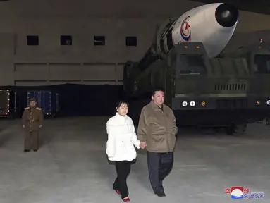 Foto yang dirilis pada 19 November 2022 ini menunjukkan pemimpin Korea Utara Kim Jong-un (kanan) dan putrinya memeriksa rudal di Bandara Internasional Pyongyang di Pyongyang, Jumat (18/11/2022). Korea Utara telah menampilkan putri yang kurang dikenal dari pemimpin negeri, Kim Jong-un di lokasi peluncuran rudal. (Korean Central News Agency/Korea News Service via AP)