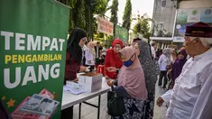 Seorang wanita lanjut usia menerima bantuan uang tunai di masjid Cheng Hoo, Surabaya, Jawa Timur pada Rabu 4 Maret 2026. Ribuan warga Kota Surabaya memadati kawasan Masjid Muhammad Cheng Hoo, Surabaya, Jawa Timur, untuk menerima penyaluran zakat mal. (JUNI KRISWANTO/AFP)