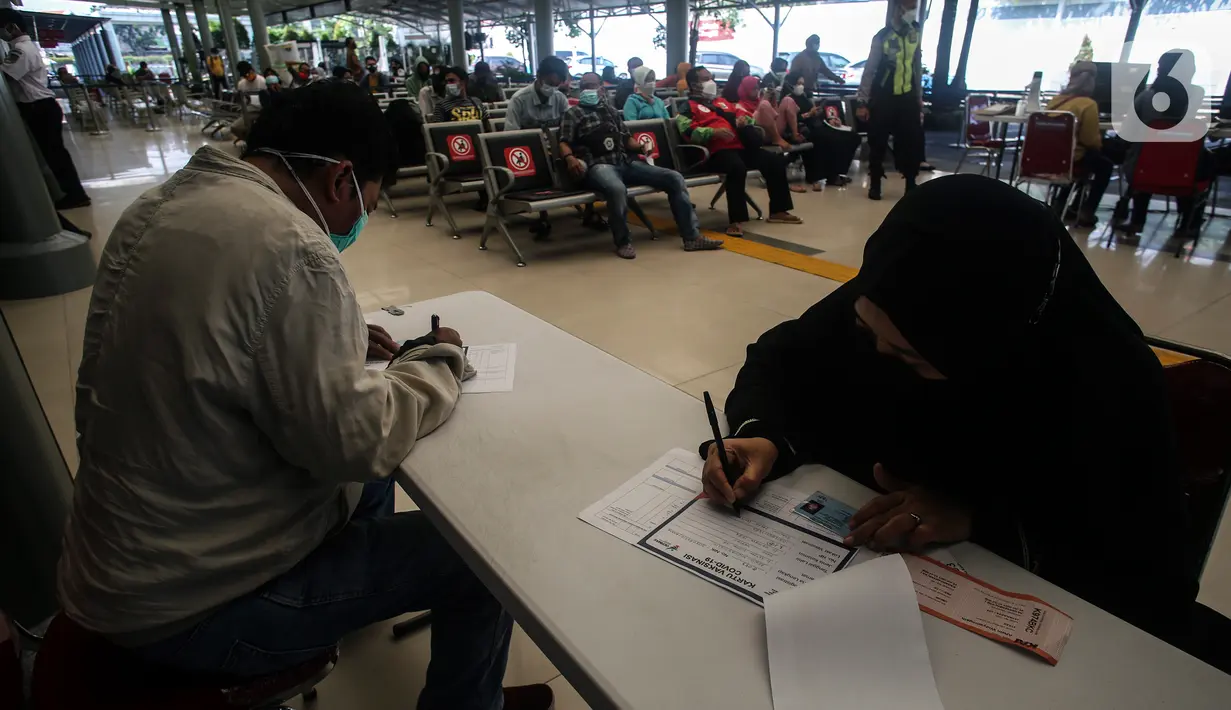 Calon penumpang kereta mengisi data untuk menerima vaksin COVID-19 di Stasiun Pasar Senen, Jakarta, Minggu (4/7/2021). PT Kereta Api Indonesia Daop 1 Jakarta membuka layanan vaksinasi Covid-19 bagi penumpangnya di Stasiun Gambir dan Pasar Senen mulai Sabtu, 3 Juli 2021. (Liputan6.com/Johan Tallo)