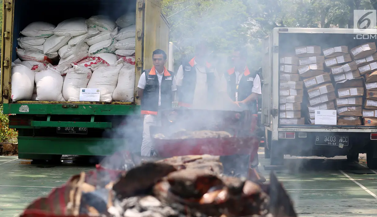 Petugas dari Kementerian Perdagangan memusnakan gula kristal dan daging beku yang sudah kedaluwarsa hasil sitaan dari pasar dengan cara di bakar, di Lapangan Parkir Kemendag, Jakarta Kamis (28/9). (Liputan6.com/JohanTallo)