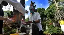 Petugas memberikan cairan hand sanitizer kepada pengurus Pura Amerta Jati menjelang persiapan Hari Raya Nyepi Saka 1942 di Cinere, Depok, Selasa (24/3/2020). Rangkaian Nyepi di sejumlah pura hanya akan dilakukan oleh panitia dalam jumlah terbatas untuk mencegah Covid-19. (merdeka.com/Arie Basuki)