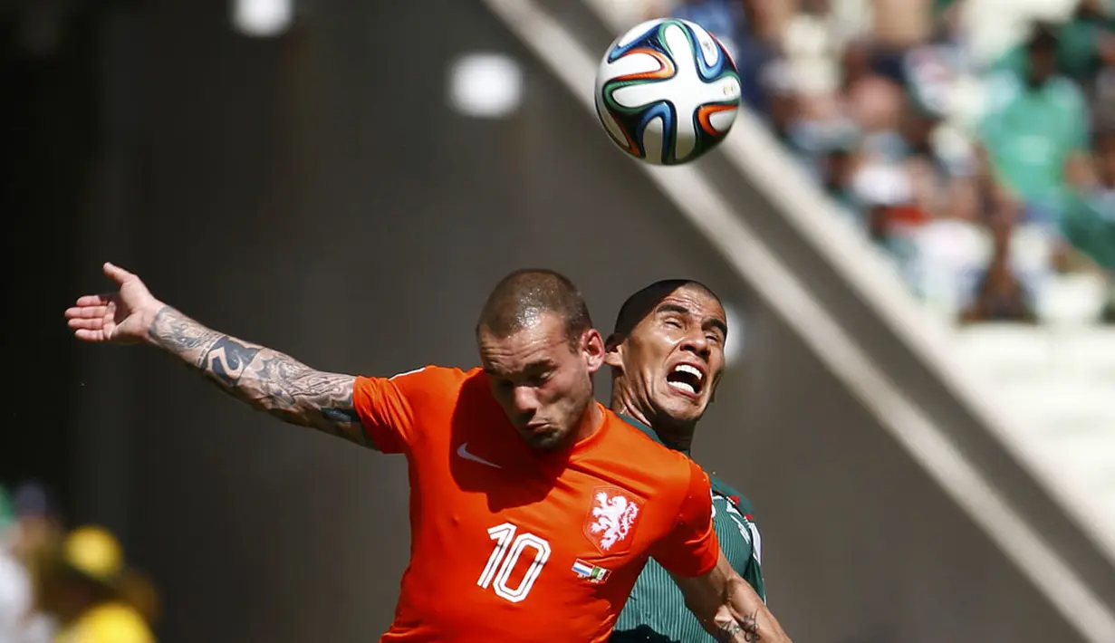 Pemain tengah Timnas Belanda, Wesley Sneijder (kiri) bertarung memperebutkan penguasaan bola dari Carlos Salcido (Meksiko) saat berlaga di 16 besar Piala Dunia 2014 diStadion Castelao, Fortaleza, (29/6/2014). (REUTERS/Dominic Ebenbichler)